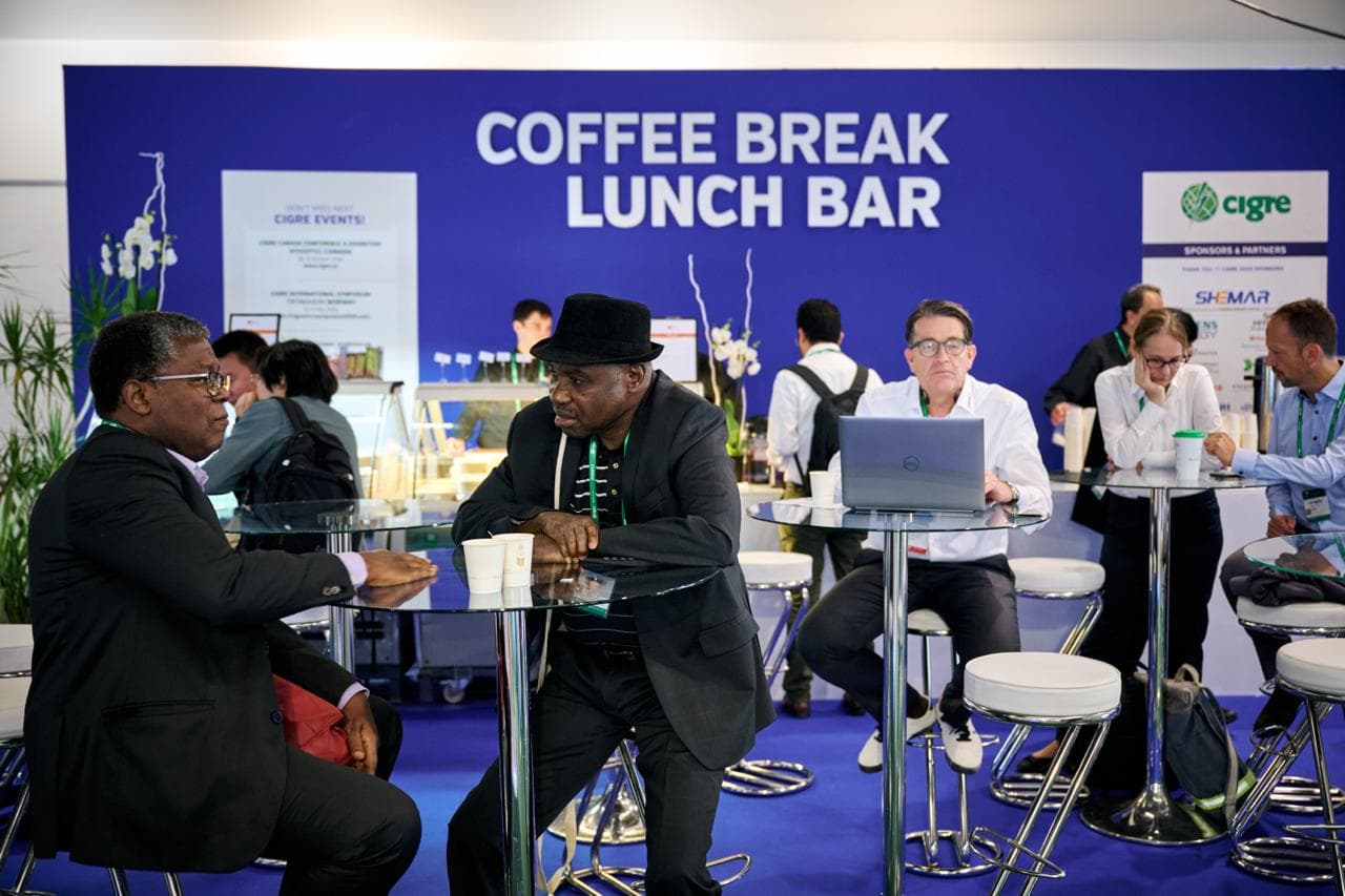 Forum attendees in conversation during a coffee break.